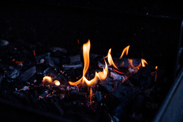 Hot BBQ Grill and Burning Fire. You can see more BBQ, grilled food, flames and fire.Empty Flaming Charcoal Grill With Flames Of Fire On Black Background Closeup. Summer Outdoor Barbeque Party