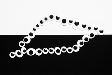 Toy eyes laid out on black and white hermetic background