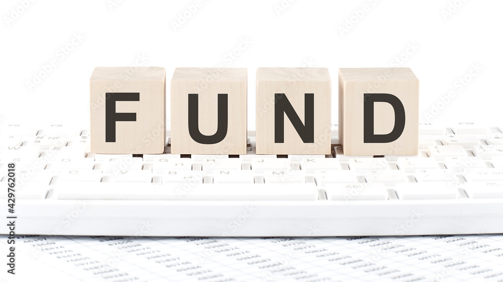 Poster fund -word wooden block on keyboard background witn chart
