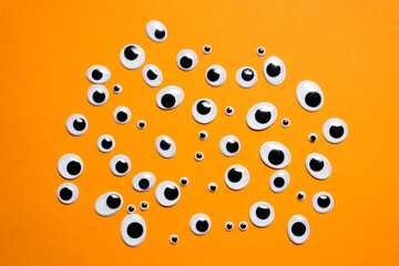 A bunch of toy eyes on an orange background