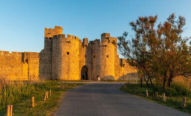 Fototapeta na wymiar Gate and east ramparts, Aigues-Mortes in the early morning, in the Gard in Occitanie, France