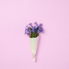 Small bouquet of blue flowers wrapped in craft paper - Nature concept of freshness and gift - Pastel colors and modern concept