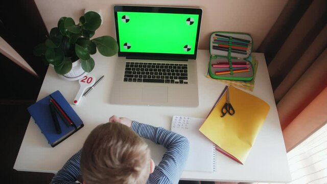 Child preschool studying homework math during his online lesson at home, social distance during quarantine. Online education and self-isolation concept. Green Screen.