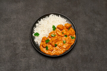 Plate of Traditional Chicken Curry and rice on dark concrete background