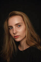 Naklejka premium cute young pretty woman with long hair in shirt posing on black background