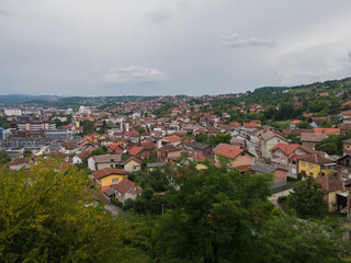 Fototapeta na wymiar Aerial view of Doboj hilly suburbs from medieval fortress Gradina during overcast summer day.