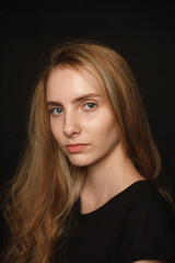 cute young pretty woman with long hair in shirt posing on black background