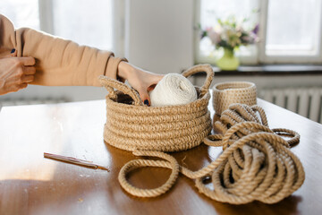 Handmade home decor made from organic jute fiber. Two wicker jute baskets are placed on a wooden...