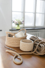 Obraz premium Handmade home decor made from organic jute fiber. Two wicker jute baskets are placed on a wooden table. jute rope and fiber. the concept of home decor and comfort in the eco style.
