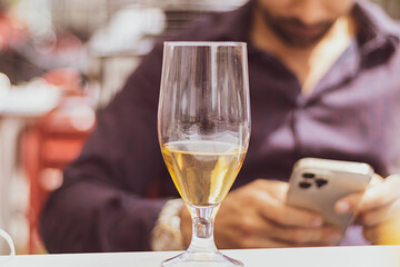 detail of a beer and behind a young businessman