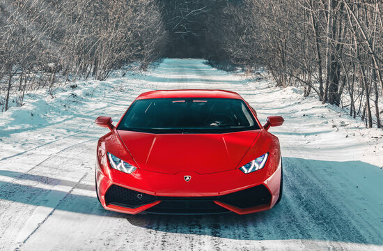 Kyiv, Ukraine - February 2020. Luxury Italian supercar Lamborghini Huracan in a red color on the winter snowy forest road.