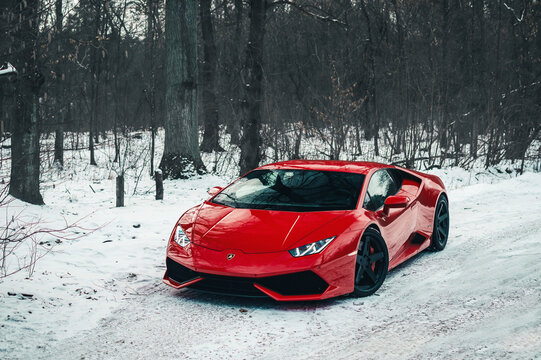 Kyiv, Ukraine - February 2020. Luxury Italian supercar Lamborghini Huracan in a red color in the winter forest.