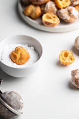 Profiteroles, buttery little pastries dusting with powered sugar  in ceramic bowl on white background Mini dessert
