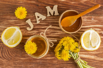 Homemade delicious dandelion jam on a wooden table with yellow dandelions. Dandelion flower syrup. Useful preservation for the winter