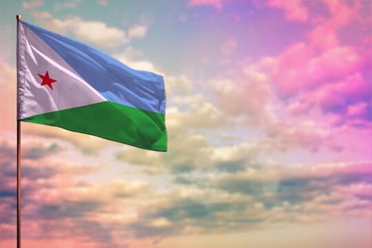Fluttering Djibouti flag mockup with the space for your content on colorful cloudy sky background.