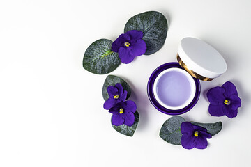 Natural cream and violet flowers on a white background, top view, place for text.