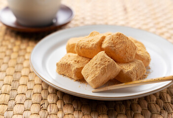 Warabi Mochi and Japanese tea on a Japanese placemat.