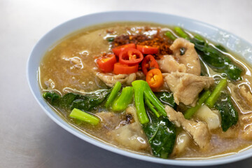 Fried noodles with pork and kale in gravy sauce (Rad-Na Moo) add pickled chili in vinegar and chili powder.