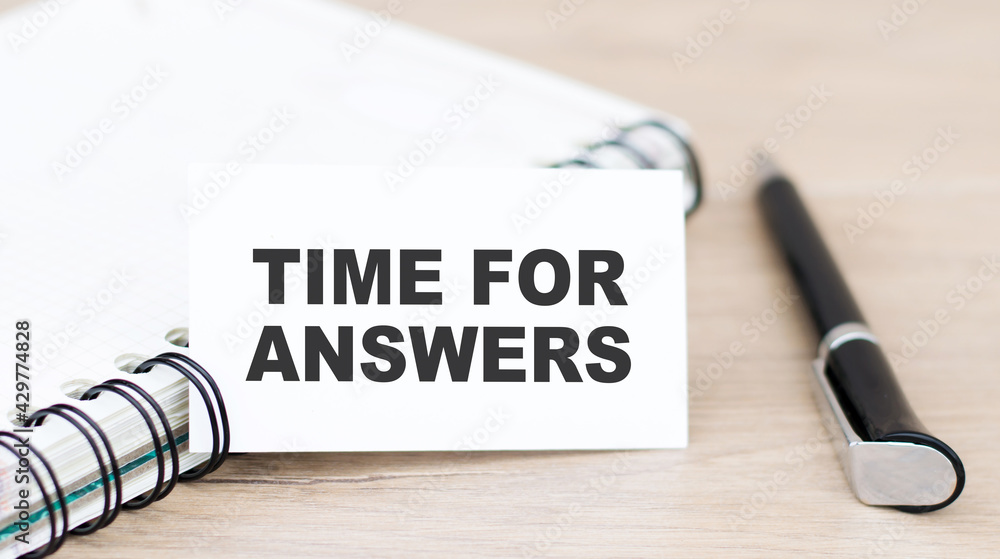 Poster a card with the text time for answers on the table next to a notebook and a black pen