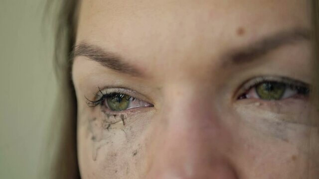Close-up. Portrait of a crying woman. Cosmetics smeared on the face.
