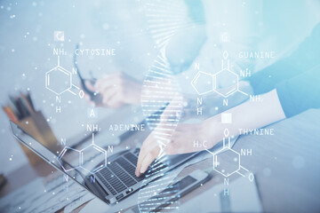 Double exposure of woman hands typing on computer and DNA hologram drawing. Medical education concept.
