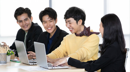 Fototapeta premium A group of multi-sex colleagues businesspeople, tomboy and transgender gay, working together with happy and intimate manner with laptop notebook computer in office