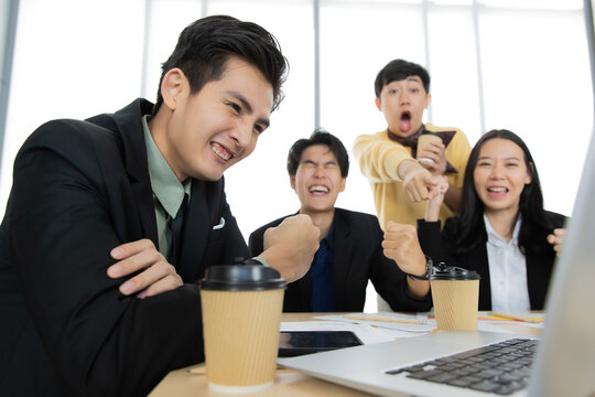 A group of multi-sex colleagues businesspeople working together with happy and intimate manner looking to laptop notebook computer screen with cheerful and excited for good news and success