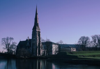 Fototapeta premium Iglesia de St Alban (Iglesia Anglicana) desde la ciudadela en Copenhague, Dinamarca (construida en 1887). Conocida localmente como la Iglesia inglesa, es una bonita iglesia de estilo neogótico.