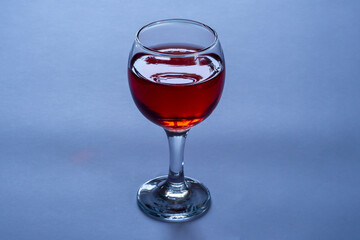 Glass of red wine on a blue background.