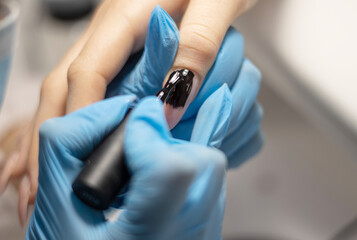 manicure in a beauty salon the process of nail polish coating