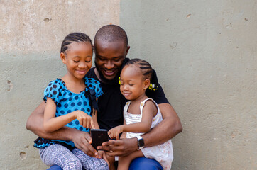 handsome african dad and his beautiful daughters feeling excited about what they saw on their...