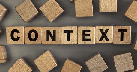 The word CONTEXT on small wooden blocks at the desk. Top view