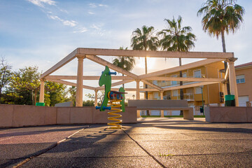 Decorative structure with stone pillars and benches in a playground.