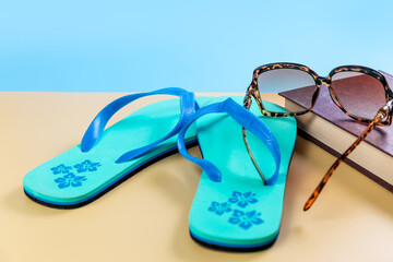 Beach slippers, flip-flops, sunglasses and a book on the seashore. Summer vacation concept....