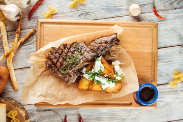 Grilled beef steak with potatoes on the wooden board