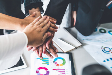 Many happy business people stacking hands together with joy and success. Company employee celebrate...