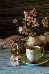 Herbal tea, candy and flowering almond twigs on a wooden table