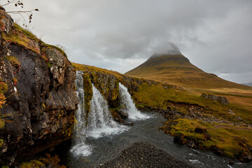 Kirkjufellsfoss waterfall with Kirkjufell cliff in the background in Iceland