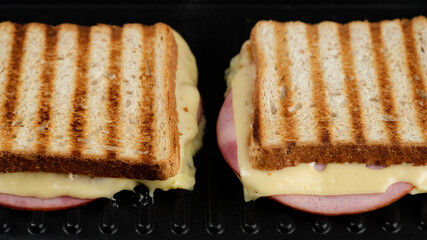 sandwich with cheese and ham on grill. grilled cheese sandwich close up