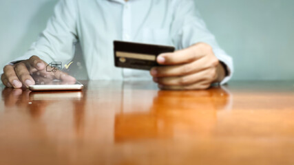Online shopping concept, young man hands holding mobile phone showing payment success information on screen on table while relax at home.