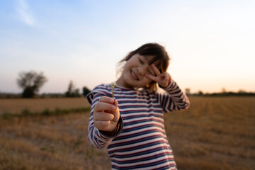 happy child girl on the meadow in summer on nature at sunset. Happy childhood