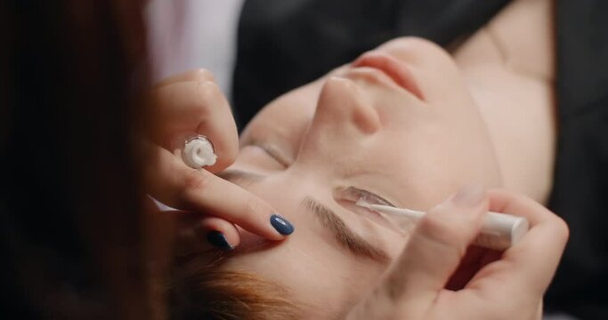 Lashmaker does the eyelash lamination procedure for the client in the beauty salon, cosmetic services, beauty care procedures, 4k 60p Prores HQ