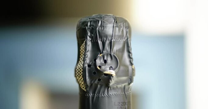 360 degree tracking shot with fast and slow speed variation from the top of a chamagne bottle with seal and stopper.