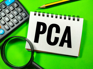 Selective focus.Word PCA (Principal Component Analysis) with calculator,pencil and magnifying glass on green background.Laboratory concept.