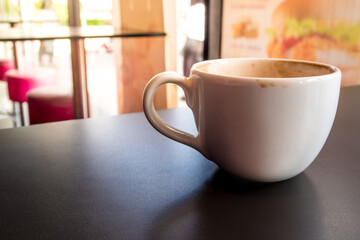 Coffee stains on white coffee cup that have been left in a coffee shop