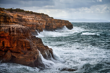 Obraz premium Stunning sea storm on a rocky shore.