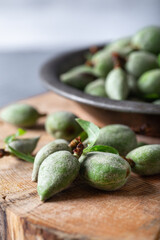 Fresh unripe almonds on the wooden background. Fresh raw green almonds.