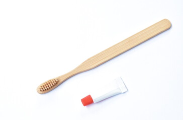 wooden toothbrush and little toothpaste tube arranging isolated on white background