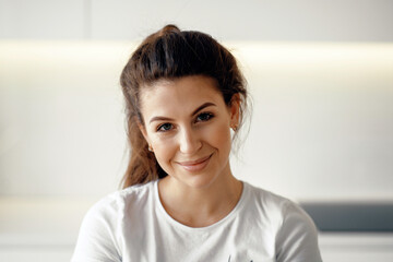 Portrait of a close woman of European appearance, looking at the camera. The beautiful brunette smiles.