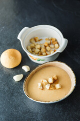 Cream soup of broccoli, potatoes, carrots with croutons on a dark background